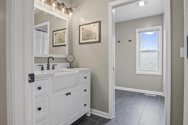 full bath with baseboards, vanity, and visible vents