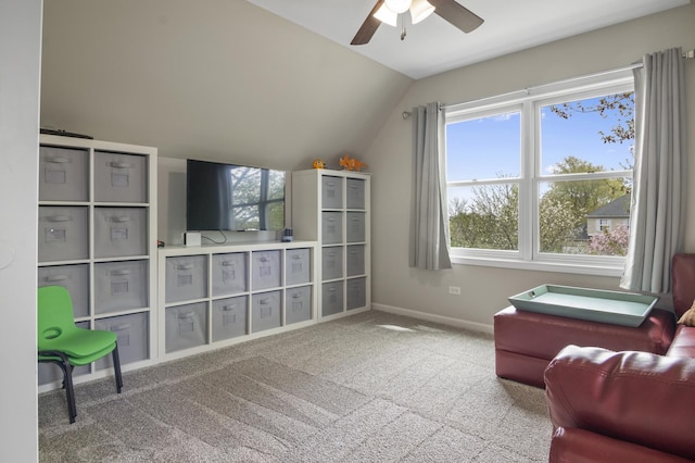living area with carpet floors, ceiling fan, vaulted ceiling, and baseboards