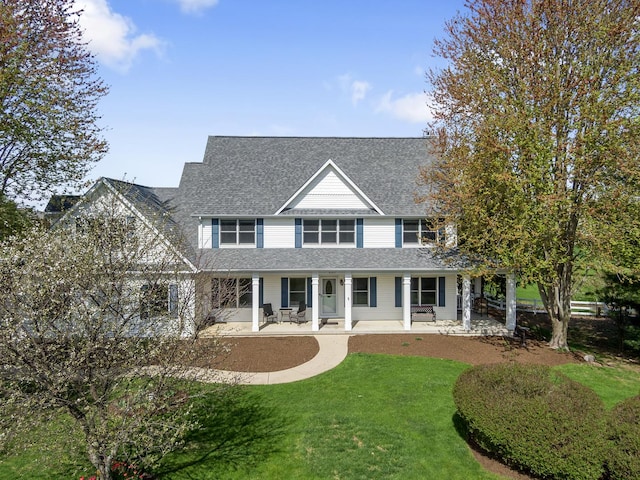 view of front of property with a shingled roof, a porch, and a front lawn