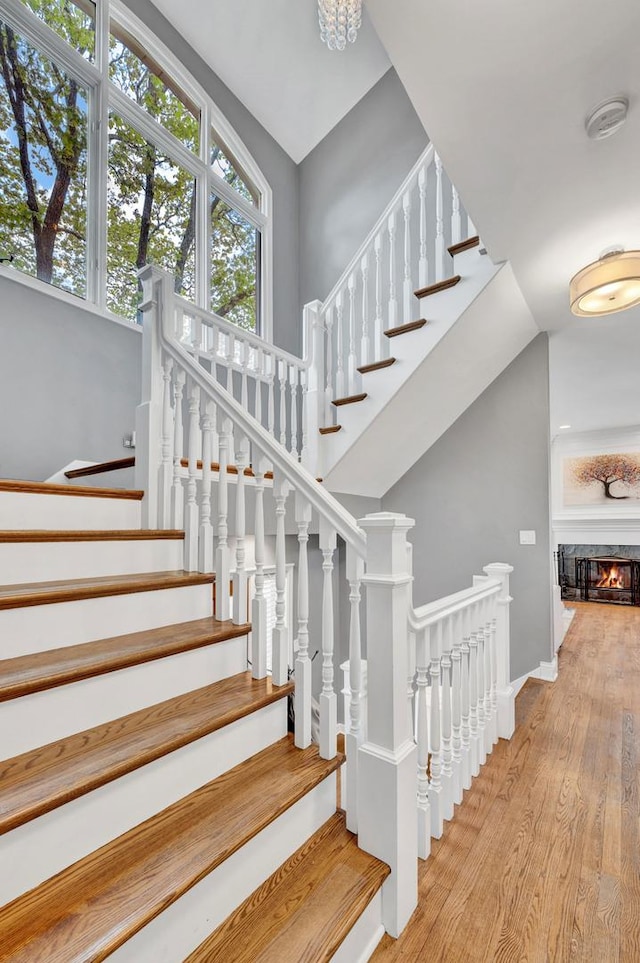 1800 W Melrose St, Chicago, IL 60657 - stairs with wood finished floors, baseboards, a glass covered fireplace, and a high ceiling