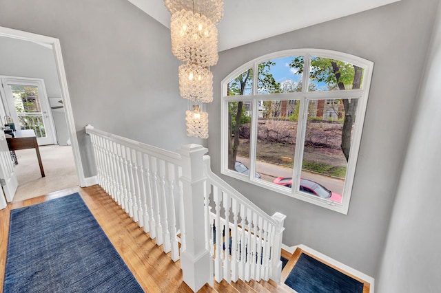 1800 W Melrose St, Chicago, IL 60657 - stairs with a chandelier, wood finished floors, and baseboards