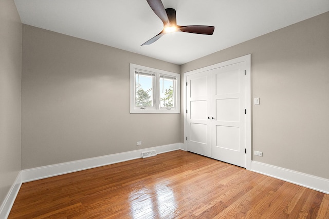 unfurnished bedroom with ceiling fan, visible vents, baseboards, a closet, and light wood-style floors
