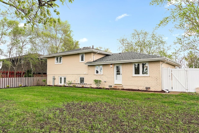 rear view of property featuring entry steps, a gate, a fenced backyard, and brick siding