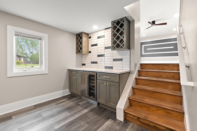 bar featuring decorative backsplash, stairs, wine cooler, dark wood-style floors, and a bar