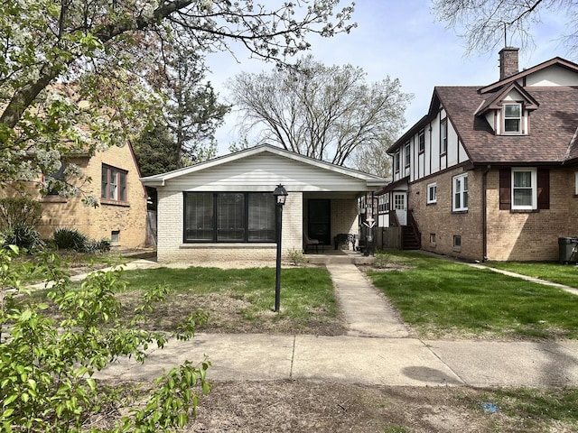 9911 Kedvale Ave, Skokie, IL 60076 - tudor home with a shingled roof, a chimney, a front lawn, and brick siding