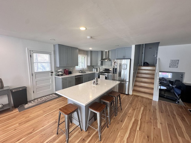 9911 Kedvale Ave, Skokie, IL 60076 - kitchen with a breakfast bar, a sink, wall chimney exhaust hood, stainless steel appliances, and gray cabinetry