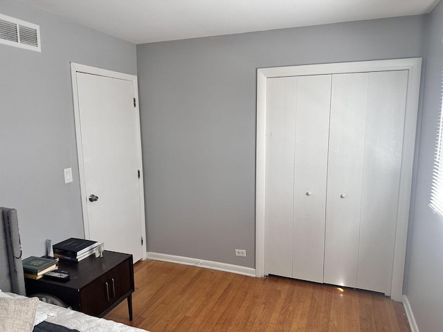 9911 Kedvale Ave, Skokie, IL 60076 - bedroom featuring baseboards, a closet, wood finished floors, and visible vents
