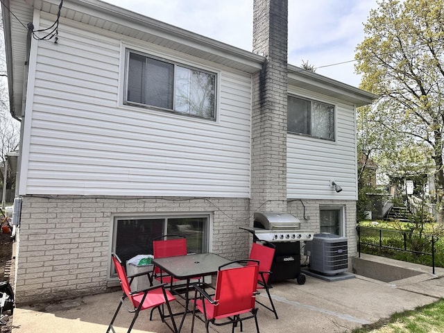 9911 Kedvale Ave, Skokie, IL 60076 - back of house featuring fence, outdoor dining space, a chimney, a patio area, and central air condition unit