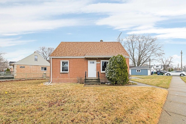 view of front of home featuring fence, entry steps, a front yard, and brick siding
