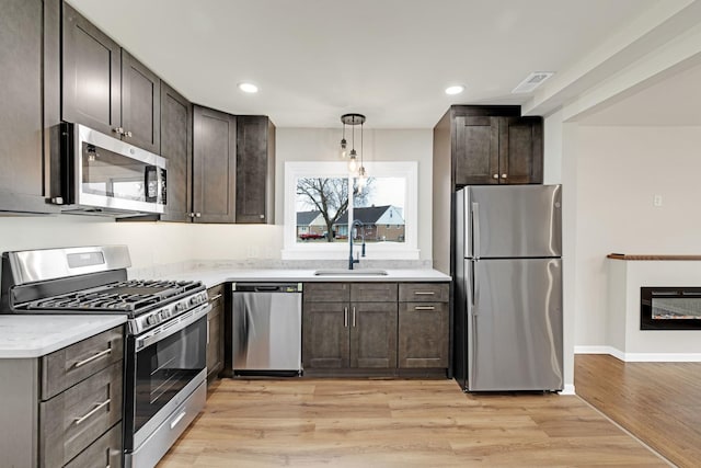 kitchen featuring a sink, light countertops, dark brown cabinetry, and stainless steel appliances