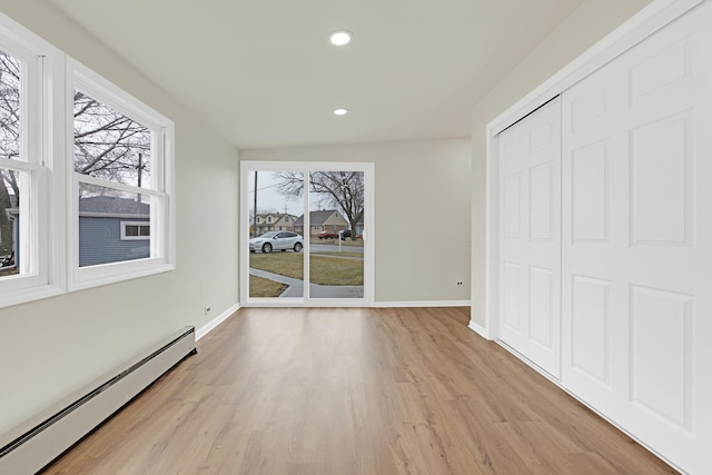 unfurnished dining area featuring recessed lighting, baseboards, a baseboard heating unit, and light wood-style flooring