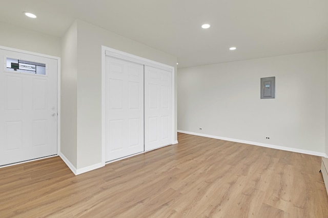 interior space featuring baseboards, recessed lighting, light wood finished floors, and electric panel