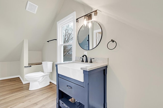 bathroom with toilet, visible vents, wood finished floors, and lofted ceiling