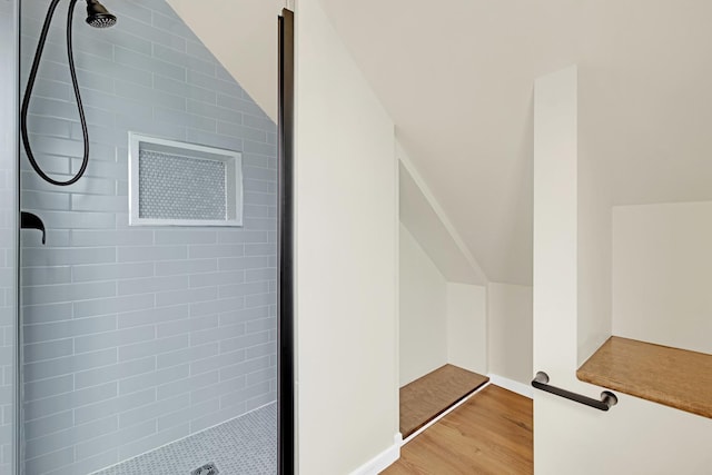 additional living space featuring light wood-style floors, baseboards, and vaulted ceiling
