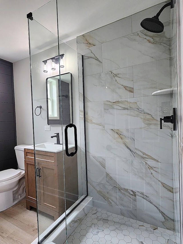 bathroom with vanity, toilet, and a stall shower