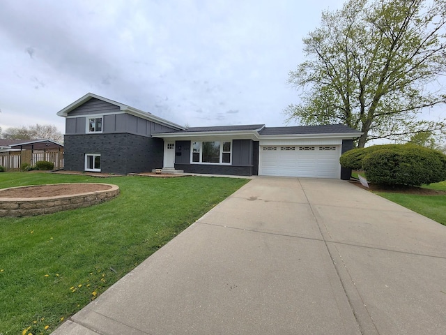 tri-level home with board and batten siding, a front yard, brick siding, concrete driveway, and an attached garage