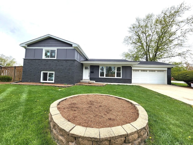 tri-level home with board and batten siding, a front yard, a garage, brick siding, and concrete driveway
