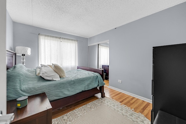 9960 Franchesca Ct Unit 2C, Orland Park, IL 60462 - bedroom with a textured ceiling, light wood finished floors, and baseboards