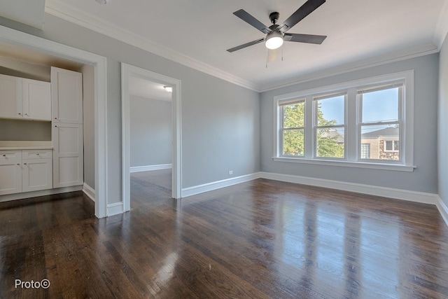 unfurnished room featuring baseboards, ornamental molding, ceiling fan, and dark wood-type flooring