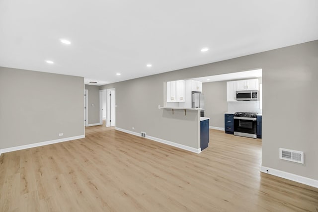 unfurnished living room featuring visible vents, recessed lighting, light wood-style flooring, and baseboards