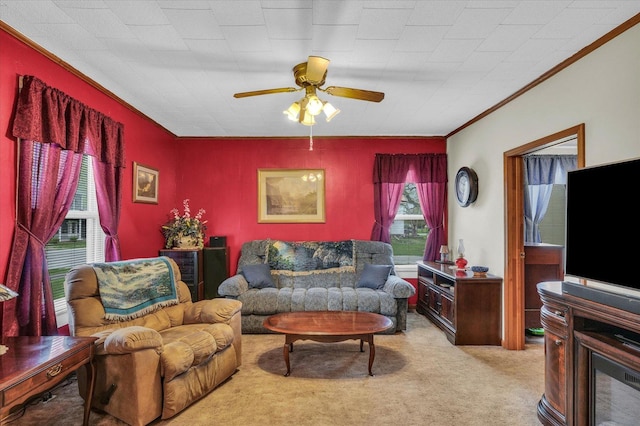 living area with ornamental molding, carpet, and ceiling fan