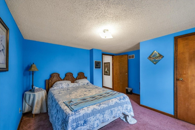 bedroom with visible vents, a textured ceiling, and carpet