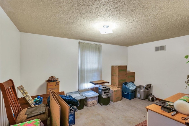miscellaneous room featuring visible vents, a textured ceiling, and carpet floors