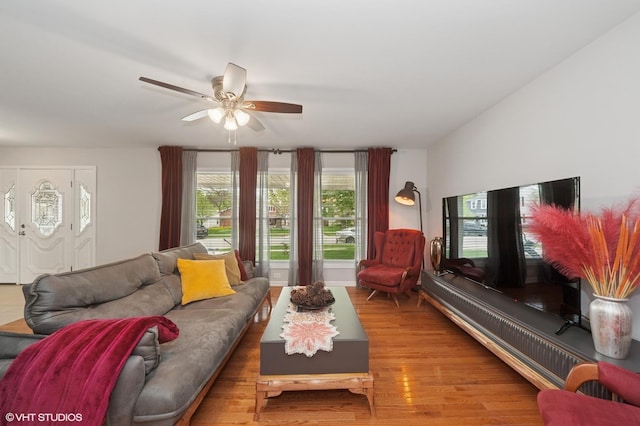 living area with a ceiling fan and wood finished floors