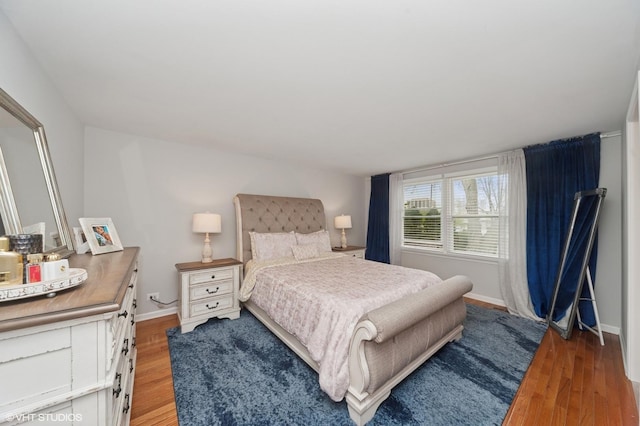 bedroom featuring baseboards and light wood finished floors