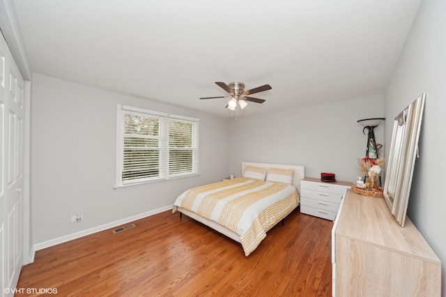 bedroom featuring light wood-style floors, baseboards, ceiling fan, and visible vents