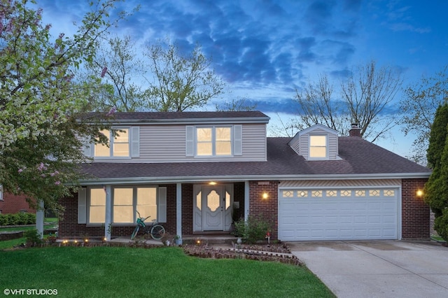 traditional home featuring a garage, a chimney, brick siding, concrete driveway, and a lawn