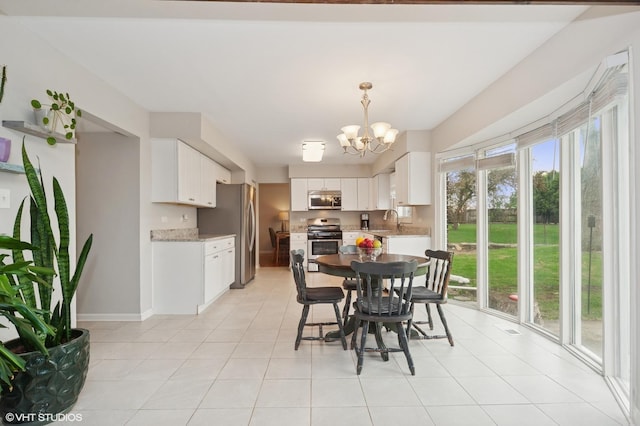 dining space with an inviting chandelier, baseboards, and light tile patterned flooring