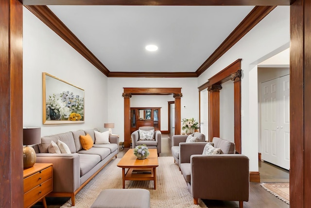 living area with ornamental molding, wood finished floors, and decorative columns