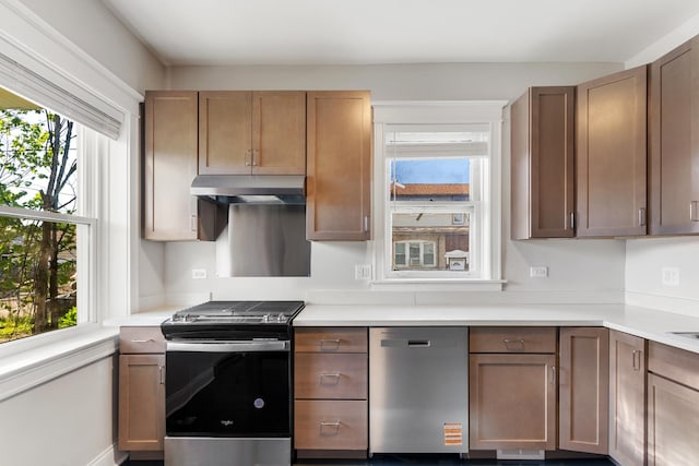 kitchen with appliances with stainless steel finishes, under cabinet range hood, and light countertops