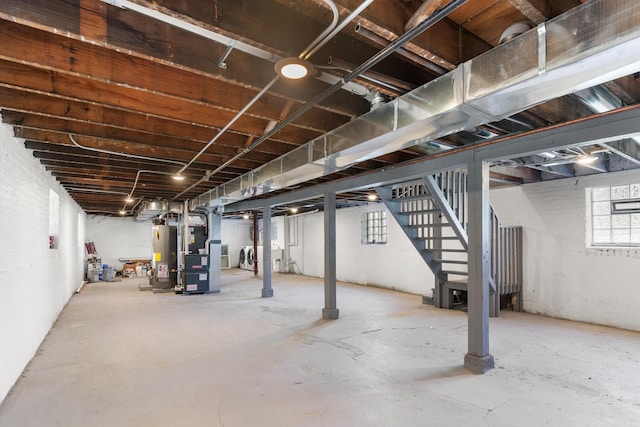 below grade area featuring gas water heater, stairs, and heating unit
