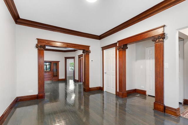 hallway with wood finished floors, crown molding, baseboards, and ornate columns