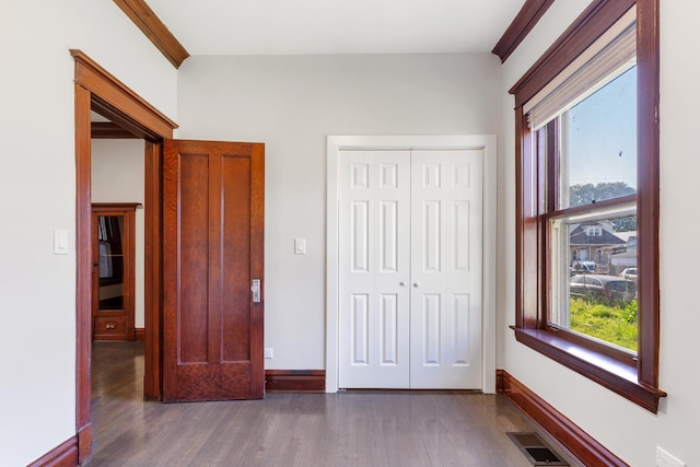 unfurnished bedroom featuring wood finished floors, a closet, and baseboards