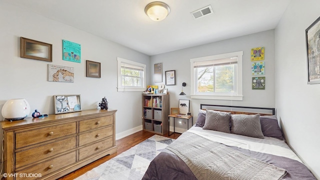bedroom with wood finished floors and baseboards