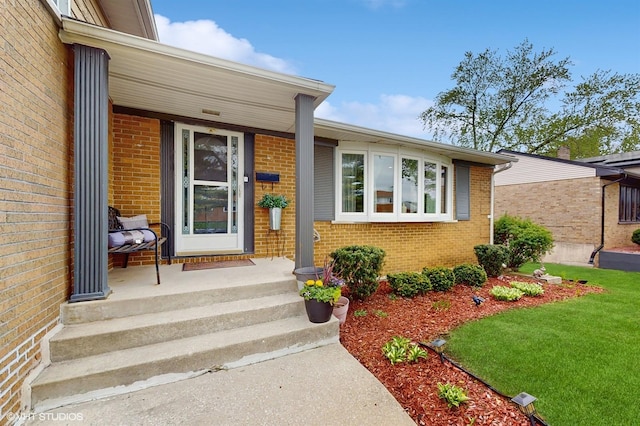 property entrance featuring brick siding and a lawn