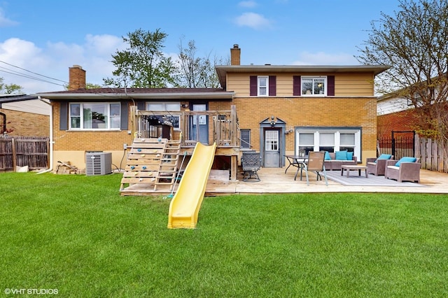 back of house featuring a chimney, brick siding, and central AC
