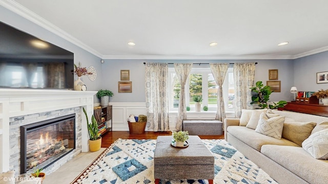 living room with crown molding, a premium fireplace, recessed lighting, a wainscoted wall, and tile patterned floors
