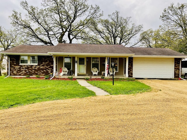 ranch-style home with covered porch, an attached garage, driveway, and a front lawn