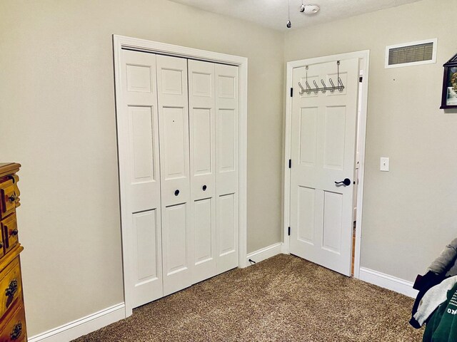 interior space featuring carpet floors, baseboards, a closet, and visible vents