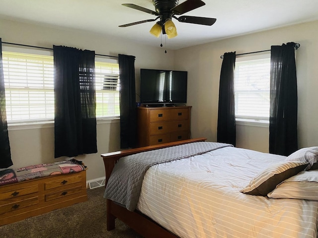 carpeted bedroom featuring ceiling fan, visible vents, and baseboards