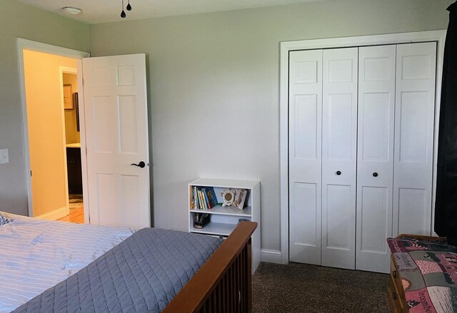 carpeted bedroom with a closet and baseboards