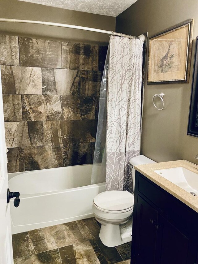 bathroom with vanity, stone finish floor, toilet, and shower / bath combination with curtain