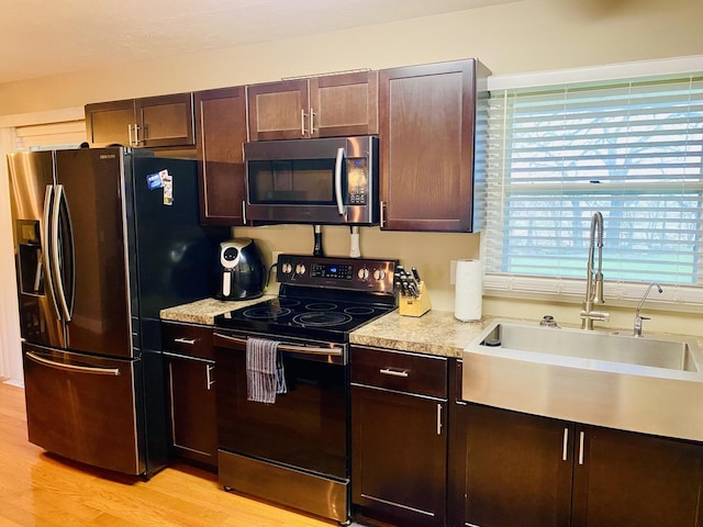 kitchen with a sink, appliances with stainless steel finishes, plenty of natural light, and light countertops
