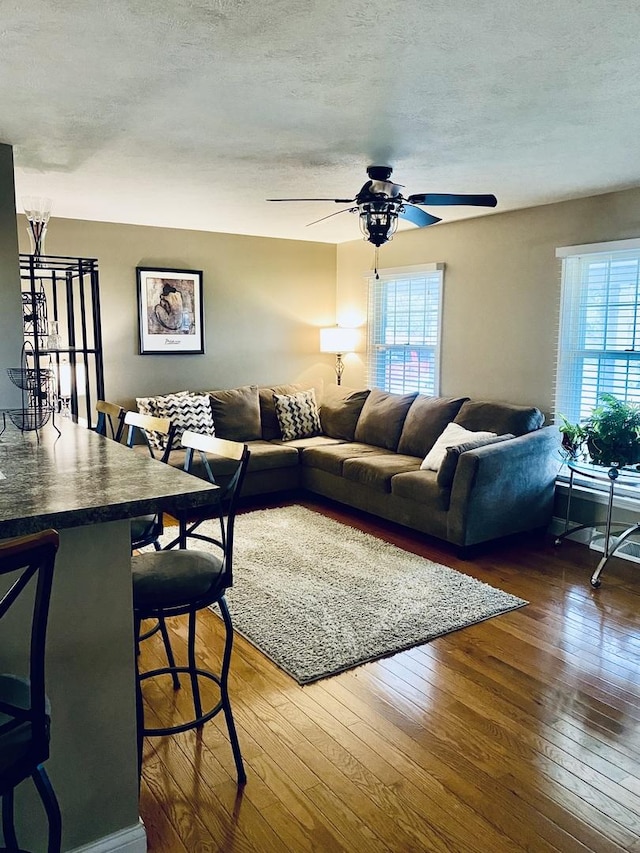 living room featuring a textured ceiling, plenty of natural light, a ceiling fan, and hardwood / wood-style floors