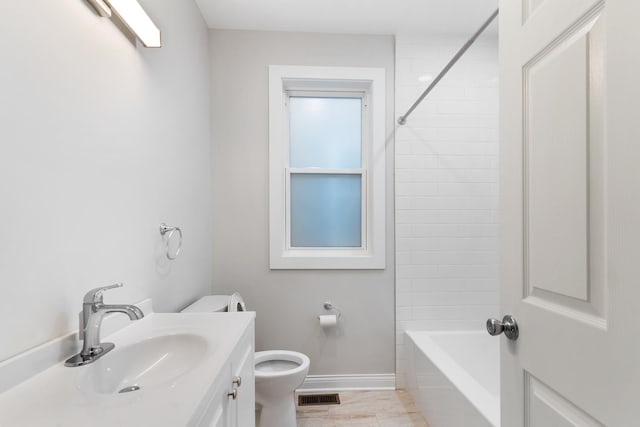 full bath featuring toilet, baseboards, vanity, and tub / shower combination