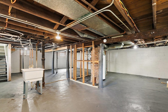 unfinished basement with water heater and stairway